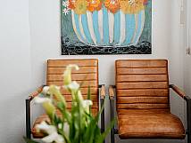 Sitzgelegenheit im Wartezimmer mit Pflanzenbild